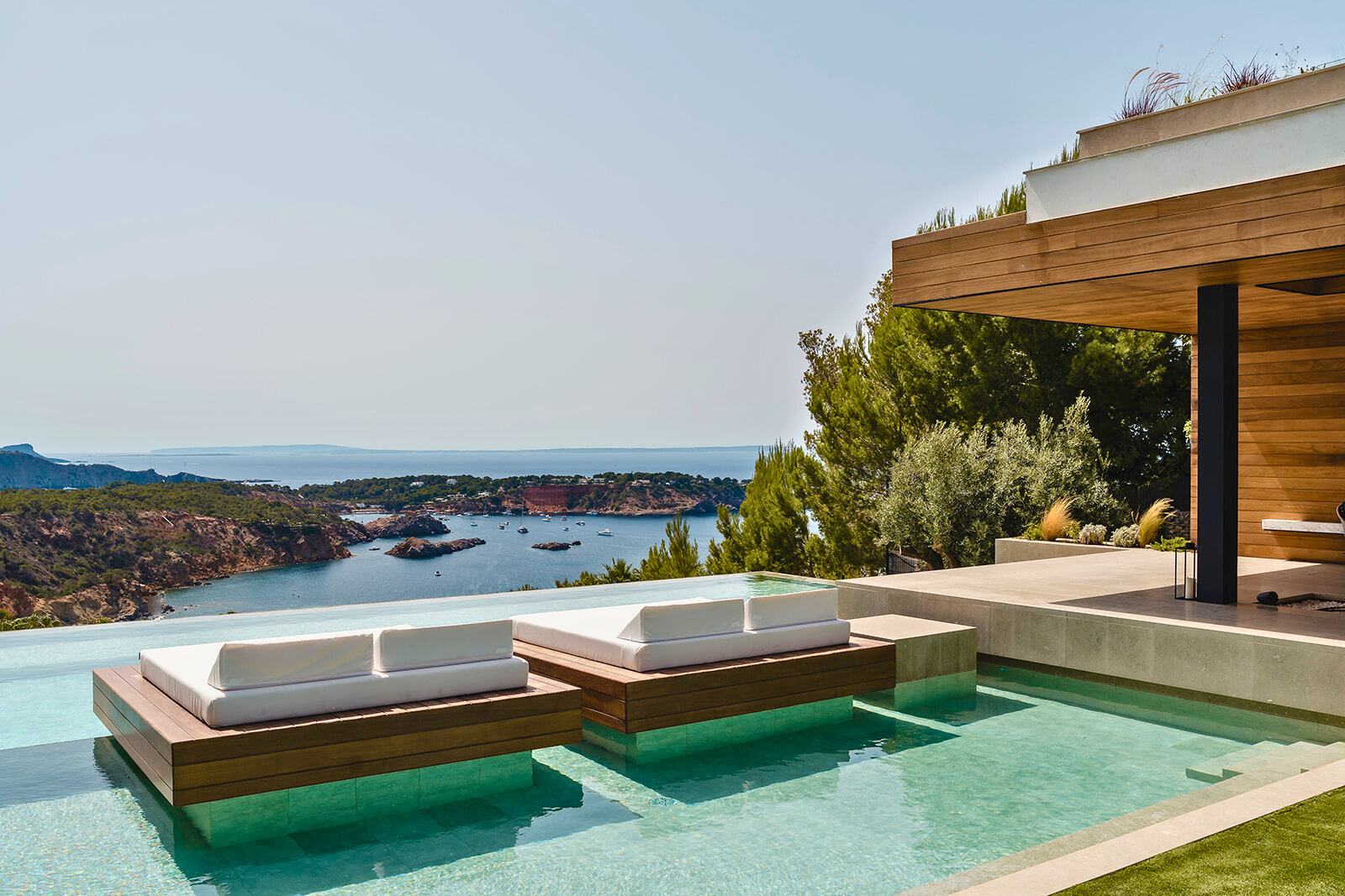 Casa Lina à Ibiza — piscine avec transats flottants et vue sur la baie